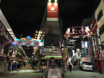 People on illuminated street at night