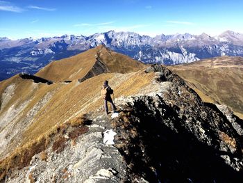 Rear view of man walking on mountain during winter