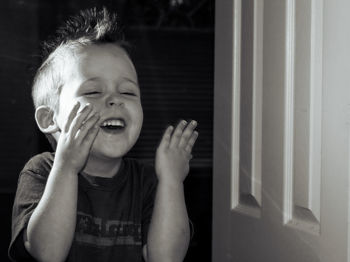 Smiling boy making a face while gesturing at home