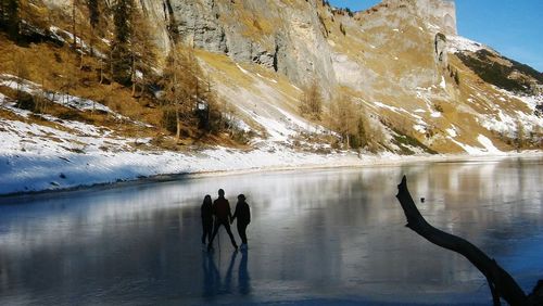 People ice-skating on frozen lake