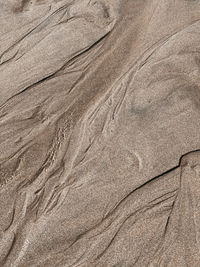 Full frame shot of water running along the sand
