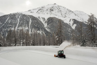 An ice skating piste and ice skating machine cleaning the snow in the alps switzerland in winter