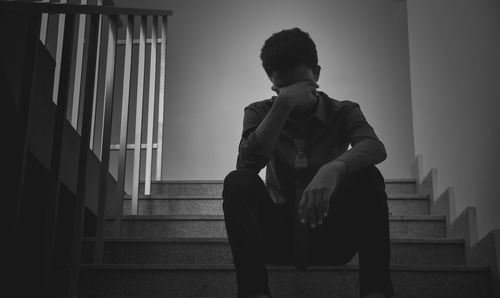 Low angle view of depressed man sitting on steps