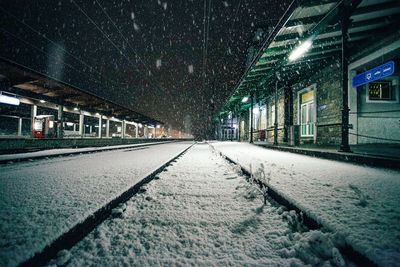 Snow covered illuminated road at night