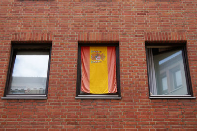 Low angle view of spanish flag in window of building