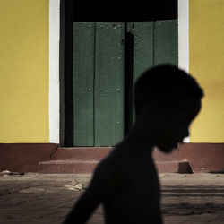 Silhouette boy against house