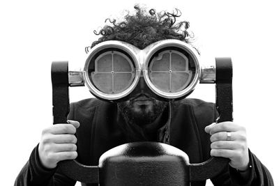 Portrait of man looking through coin-operated binoculars against clear sky