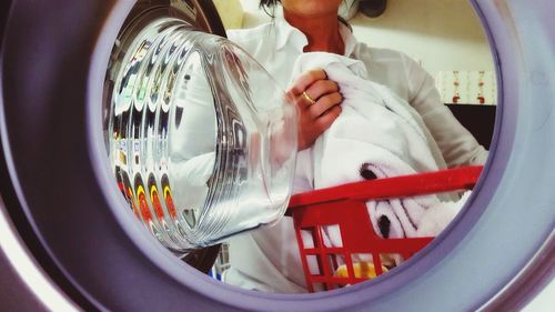 Midsection of woman washing clothes in laundromat