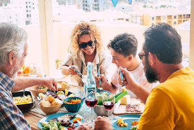 Cheerful family having food on table