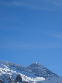 Scenic view of snowcapped mountains against blue sky