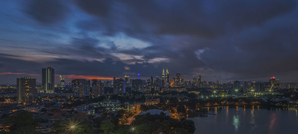 Illuminated buildings in city against sky