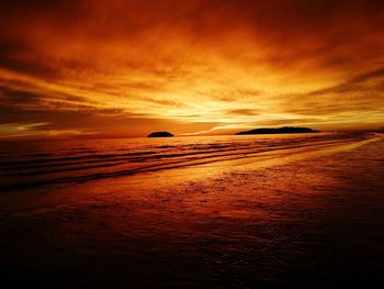 Scenic view of sea against cloudy sky at sunset