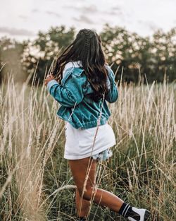 Rear view of woman standing on field