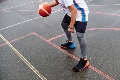 Cropped image of unrecognizable male playing basketball at the court. sport concept.