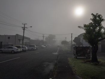 Cars on road against sky in city