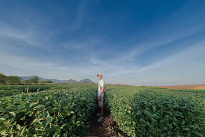 Woman standing on field against sky