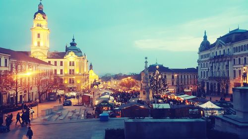 Illuminated city against sky at dusk