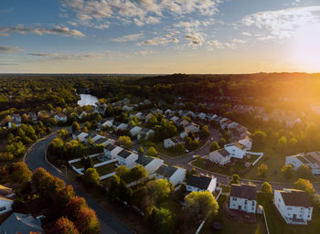 High angle view of houses and trees on field against sky