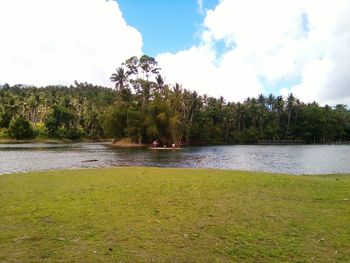 Scenic view of lake by trees against sky