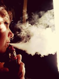 Close-up of woman smoking electronic cigarette indoors