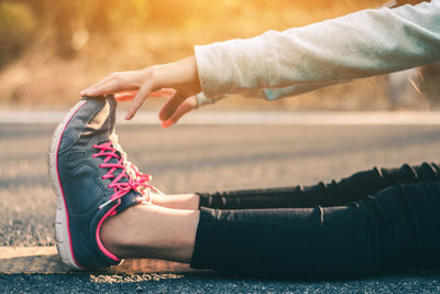Low section of woman sitting on road