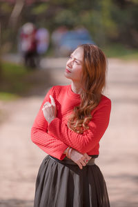 Woman looking away while standing outdoors