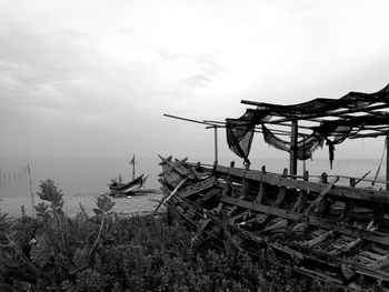 Traditional windmill by sea against sky