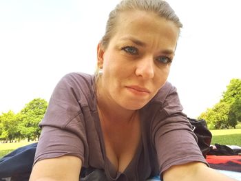 Portrait of woman sitting against sky