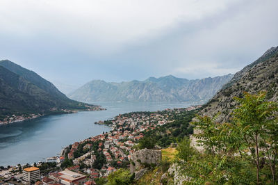 Scenic view of townscape by mountains against sky