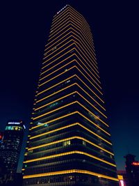 Low angle view of illuminated buildings against sky at night