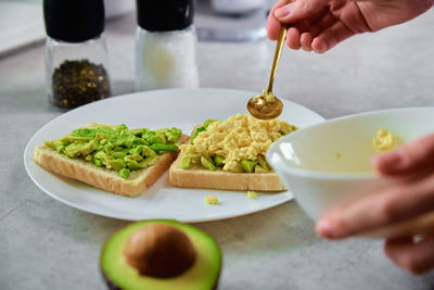 Woman preparing toasts with avocado, healthy food and dieting concept, organic product