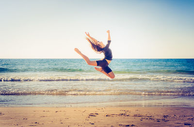 Woman jumping on beach