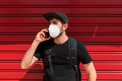 Full length of man standing against red wall