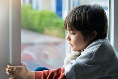 Boy looking through window