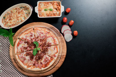 Directly above shot of pizza on table against black background