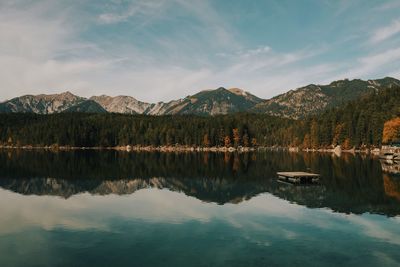 Scenic view of lake by mountains against sky