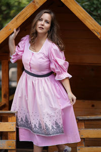 Young woman standing against wall