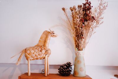 Close-up of vase on table against wall