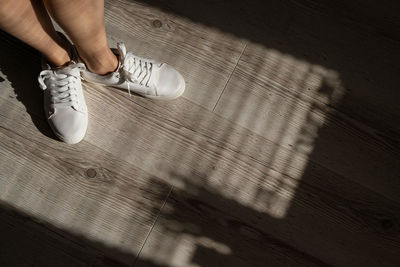 Low section of woman on wooden floor