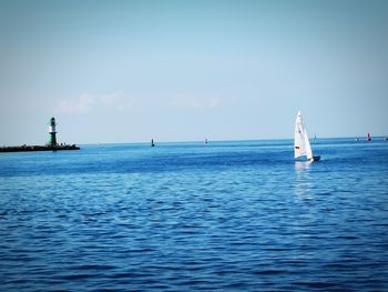 Sailboat sailing on sea against sky