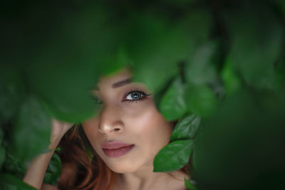 Close-up portrait of young woman with leaves