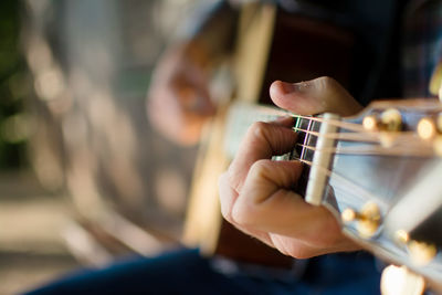 Midsection of man playing guitar