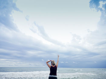 Man standing at beach against sky