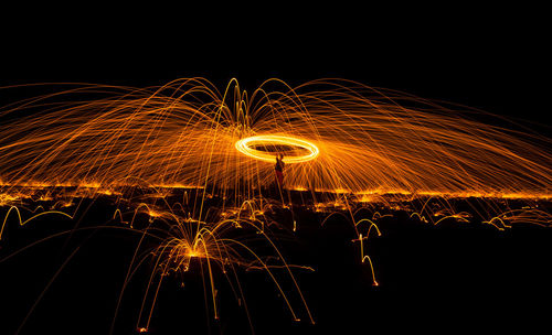 Person spinning wire wool at night