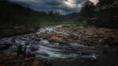 Scenic view of river amidst trees against sky