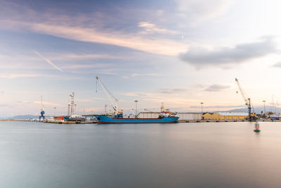 Long exposure photography in the port at sunset. cranes at commercial dock against sky.