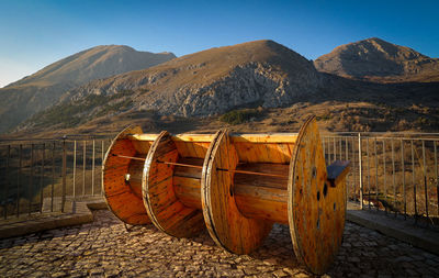 Strange cylinder-shaped bench with a view of the apennine mountain range. terrace with railing.
