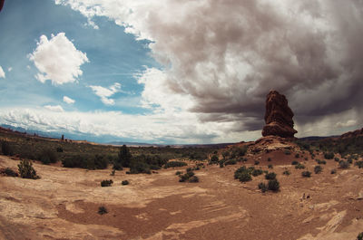 Scenic view of desert against cloudy sky