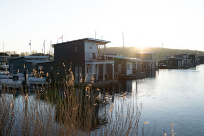 Houses by lake during sunset