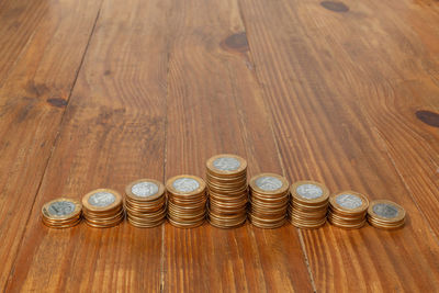 High angle view of coins on wooden table